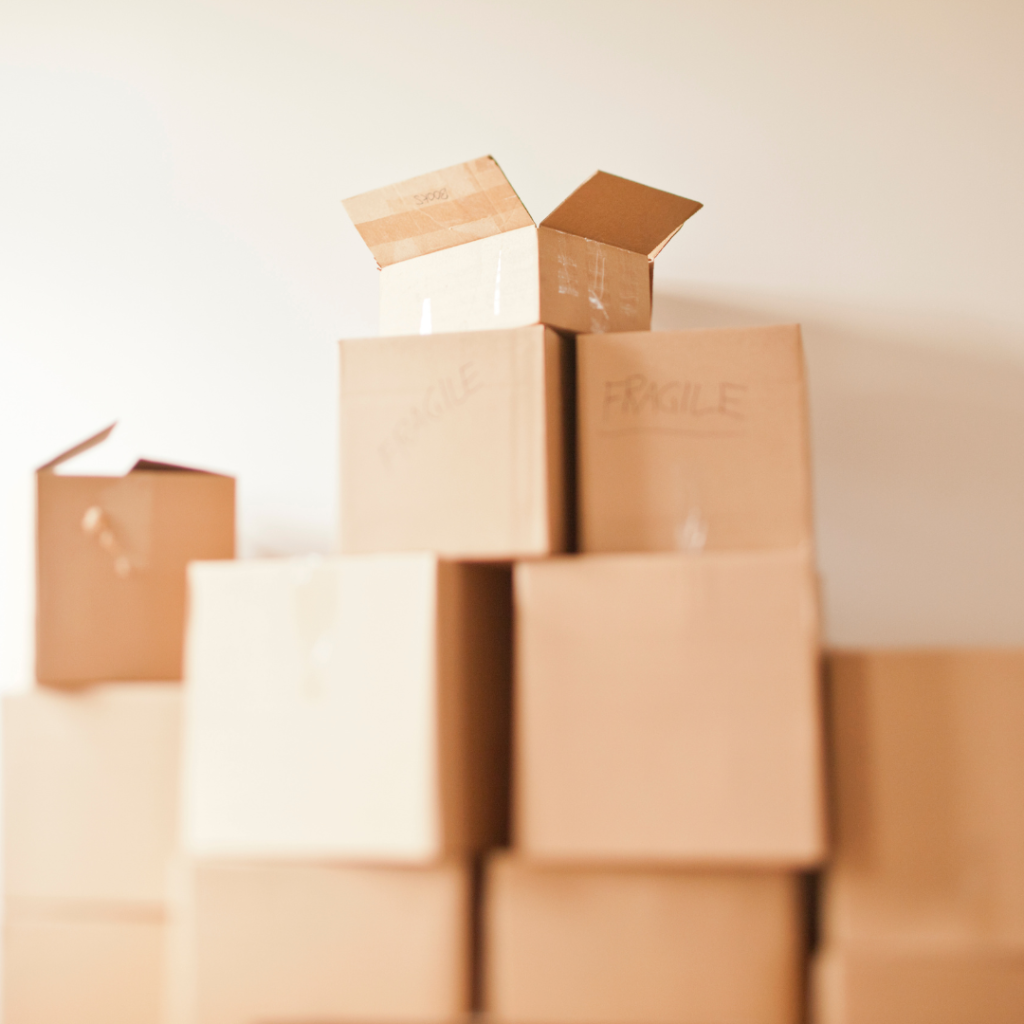 several stacks of cardboard moving boxes against a white background | moving boxes near me