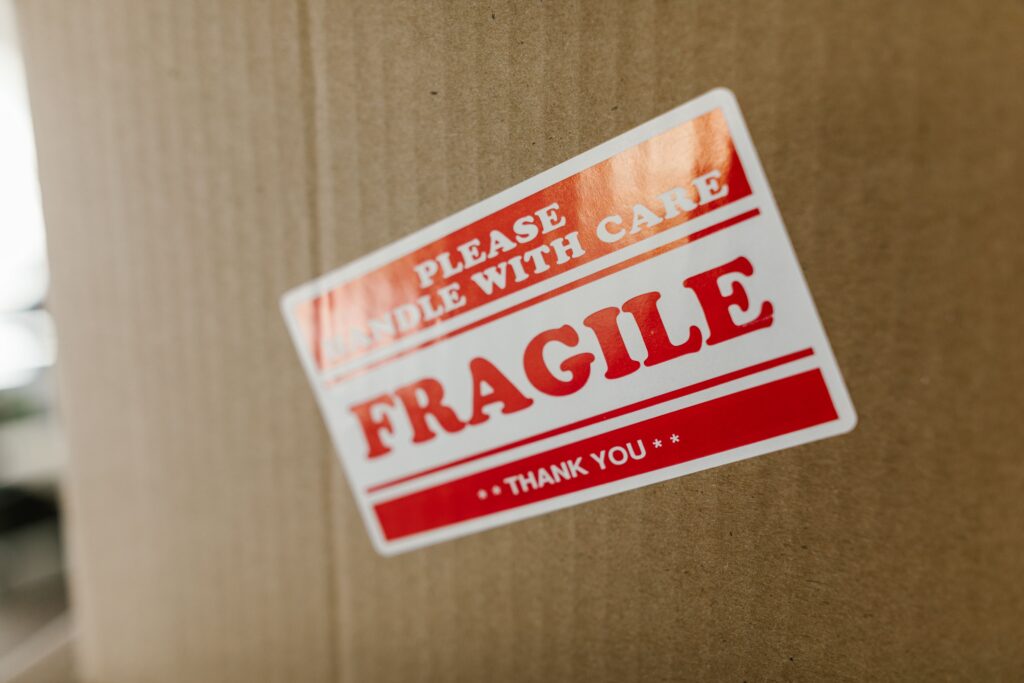 Fragile sticker on cardboard box, handle with care.